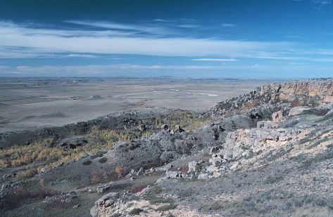 The southwest edge of Black Butte, Slope County. Note that numerous sandstone blocks litter this slope. These blocks broke from the caprock and toppled and slid 
								down the slope. Snow Cave was located in this general area. 